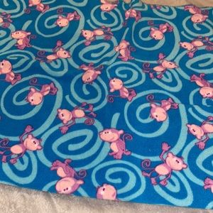 Blue blanket with purple monkeys on it.